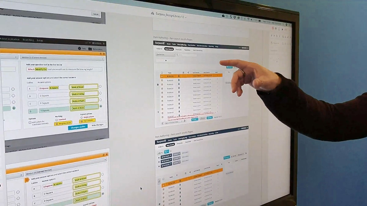 UX Designer pointing at a mockup of new features in the Surpass Platform